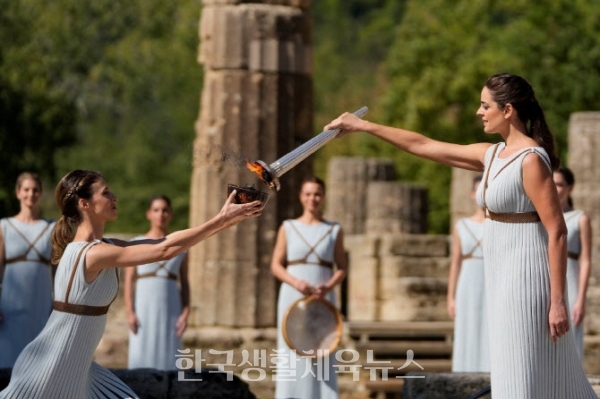 18일(현지시각) 그리스의 고대 올림픽 발상지에서 성화를 옮겨주고 있다.